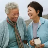 Two older adults females friends laughing together