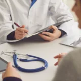 Doctor writing in a clibboard