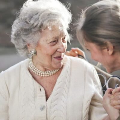 Adult woman holding her elderly mom's hands